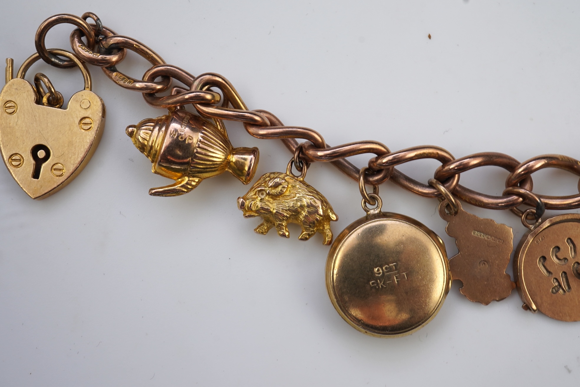 A gold charm bracelet, mid 20th century